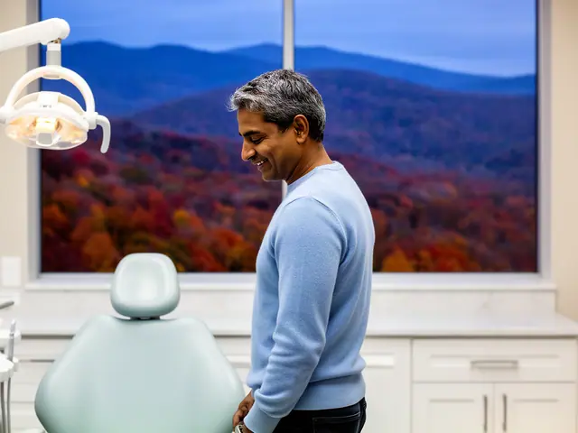 A dentist standing beside a dental chair.